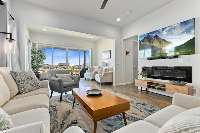 living room featuring ceiling fan and hardwood / wood-style floors