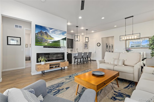 living room with hardwood / wood-style flooring and an inviting chandelier