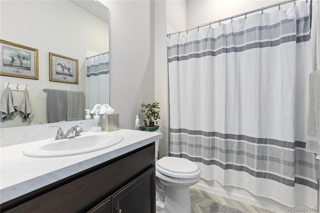 bathroom featuring parquet floors, vanity, and toilet