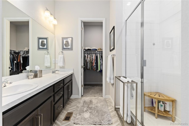 bathroom with a shower with door and vanity