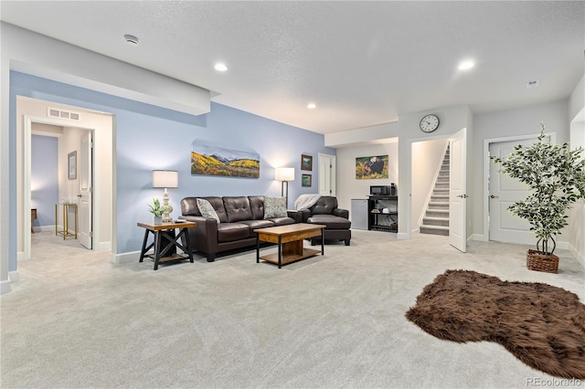 living room featuring light colored carpet and a textured ceiling