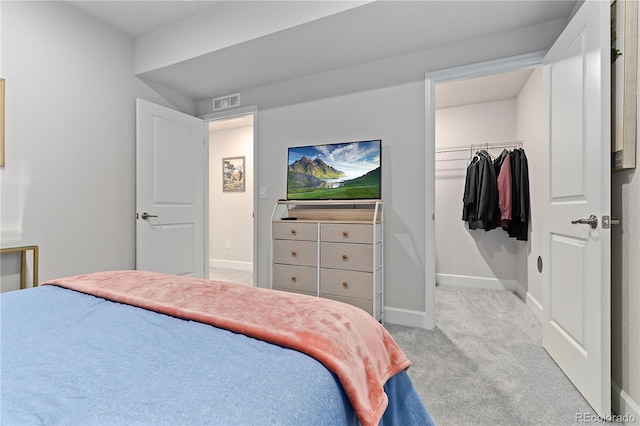 carpeted bedroom featuring a spacious closet and a closet