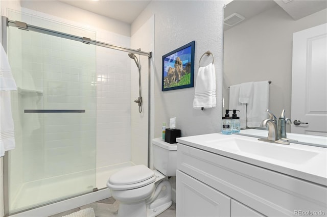 bathroom with vanity, toilet, and a shower with shower door