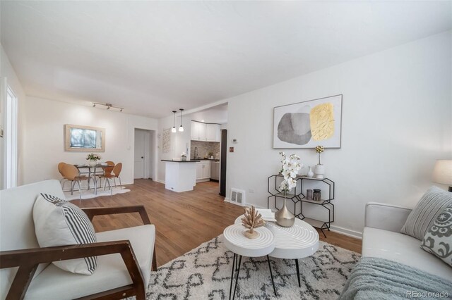 7275 E 8th Ave, Denver, CO 80220 - living room featuring light wood-style flooring and baseboards