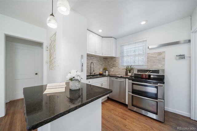 7275 E 8th Ave, Denver, CO 80220 - kitchen featuring stainless steel appliances, a sink, white cabinets, tasteful backsplash, and dark stone counters