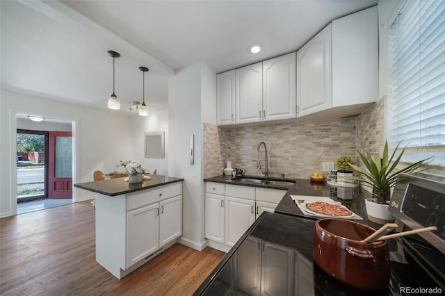 7275 E 8th Ave, Denver, CO 80220 - kitchen featuring a sink, dark countertops, a peninsula, white cabinetry, and recessed lighting