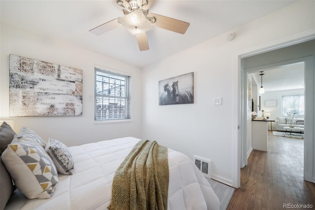 7275 E 8th Ave, Denver, CO 80220 - bedroom featuring multiple windows, wood finished floors, baseboards, and a ceiling fan