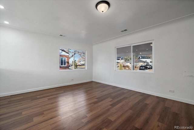 unfurnished room with dark wood-type flooring