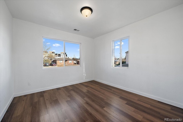 unfurnished room with plenty of natural light and dark wood-type flooring