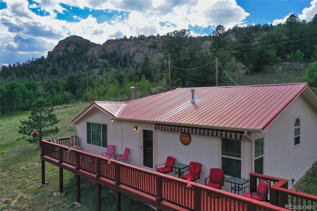 rear view of house featuring a wooden deck