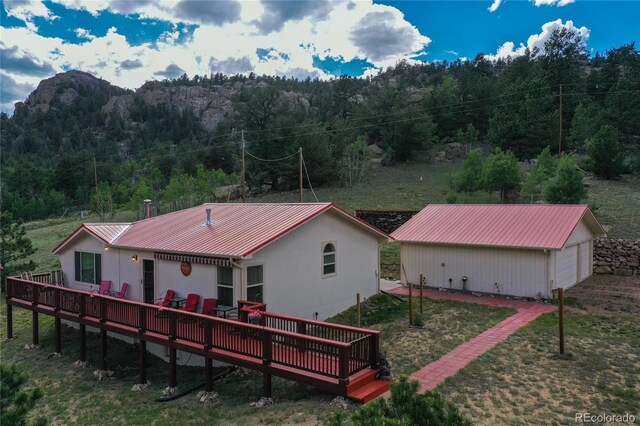 back of house with an outbuilding and a wooden deck