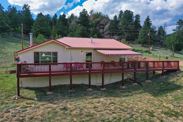 back of house featuring a wooden deck and a yard