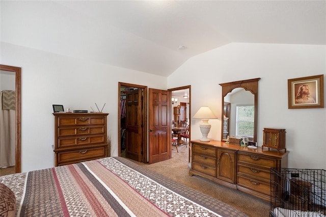 bedroom with vaulted ceiling, carpet, a closet, and a walk in closet