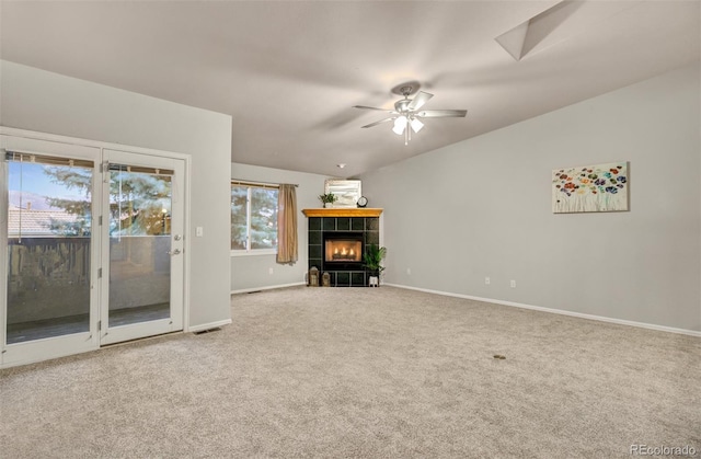 unfurnished living room featuring a fireplace, ceiling fan, lofted ceiling, and carpet