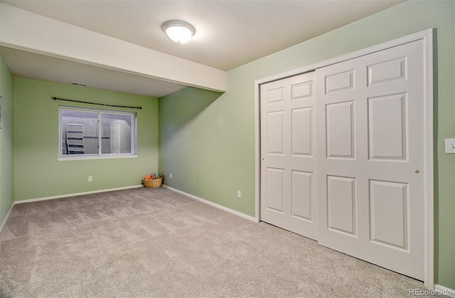 unfurnished bedroom featuring light carpet and a closet