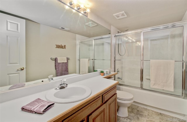 full bathroom featuring vanity, combined bath / shower with glass door, and toilet