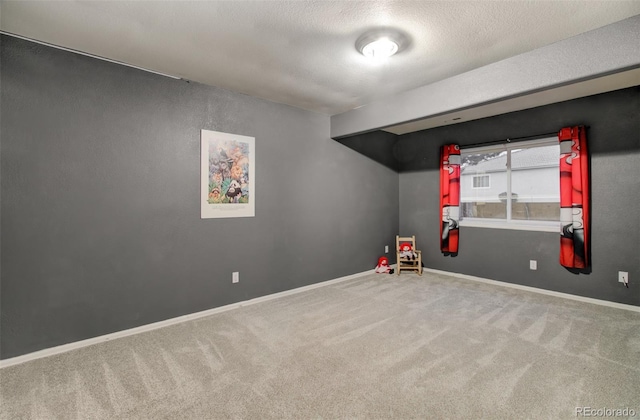 spare room featuring a textured ceiling and carpet flooring