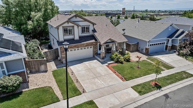 16352 E 104th Way, Commerce City, CO 80022 - view of front facade with driveway, stone siding, a shingled roof, and stucco siding