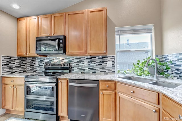 16352 E 104th Way, Commerce City, CO 80022 - kitchen with stainless steel appliances, backsplash, light stone counters, light brown cabinetry, and a textured wall