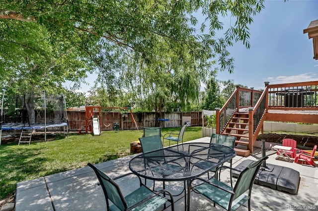16352 E 104th Way, Commerce City, CO 80022 - fenced backyard with a trampoline, outdoor dining space, a patio, and stairway