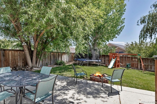16352 E 104th Way, Commerce City, CO 80022 - fenced backyard featuring a patio, a playground, a trampoline, a fire pit, and outdoor dining area