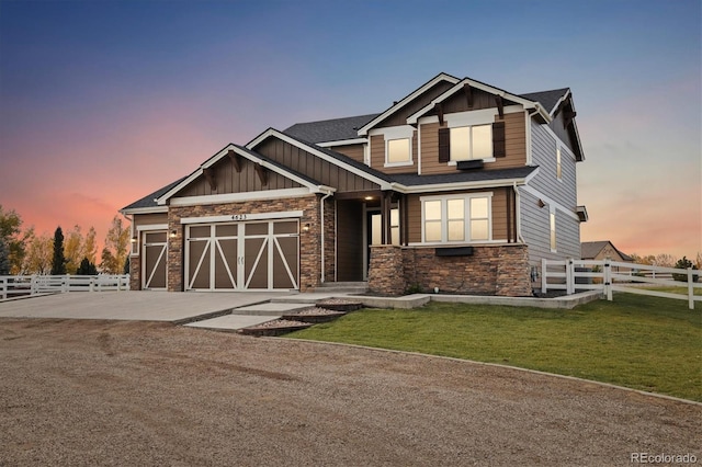 craftsman inspired home featuring a garage and a lawn