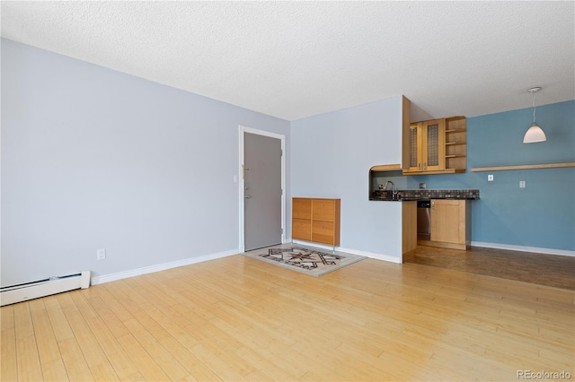 850 W Moorhead Cir Unit 3L, Boulder, CO 80305 - unfurnished living room featuring a baseboard radiator, light wood-style flooring, and a textured ceiling