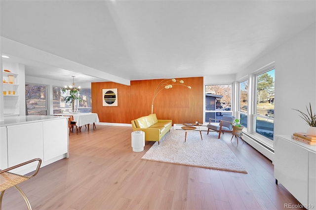 living room featuring wood walls, beam ceiling, wood-type flooring, a chandelier, and a baseboard radiator