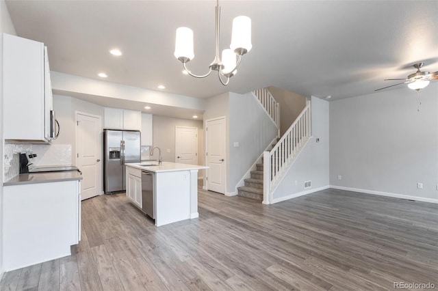 2561 Stage Coach Dr Unit B, Milliken, CO 80543 - kitchen with stainless steel appliances, a ceiling fan, open floor plan, baseboards, and white cabinets