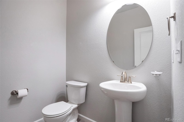 2561 Stage Coach Dr Unit B, Milliken, CO 80543 - half bathroom featuring toilet, a sink, and baseboards