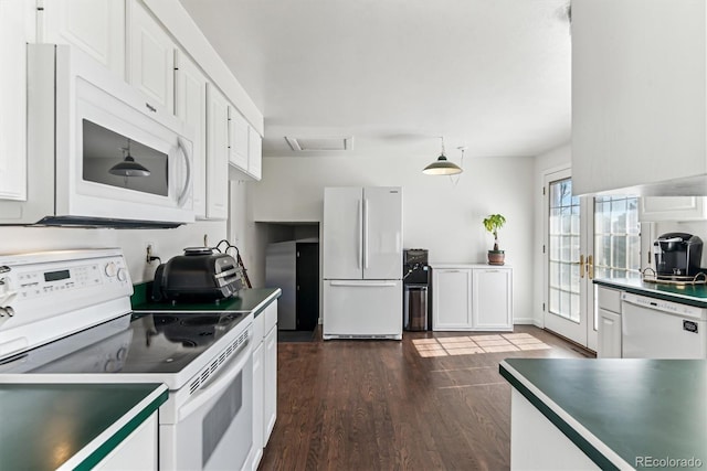 kitchen featuring white cabinetry, white appliances, hanging light fixtures, and dark wood-type flooring