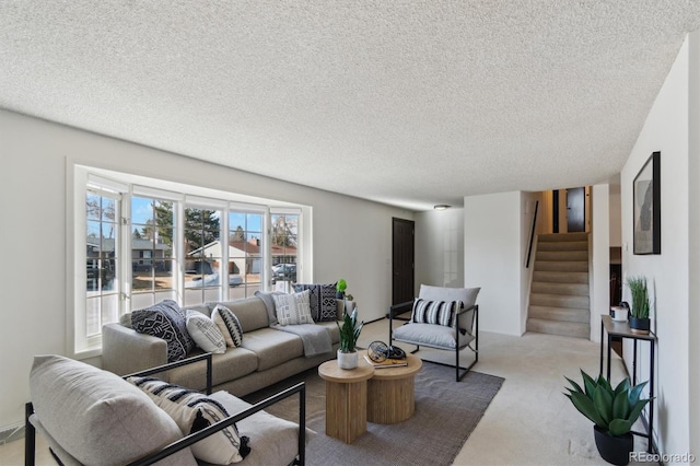 living room with stairway, light colored carpet, and a textured ceiling