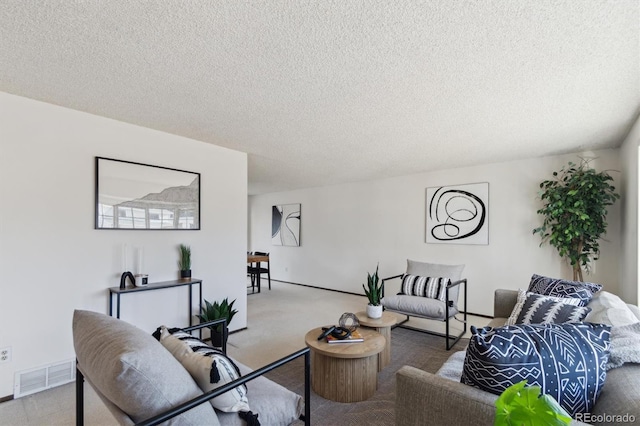 carpeted living room featuring visible vents and a textured ceiling