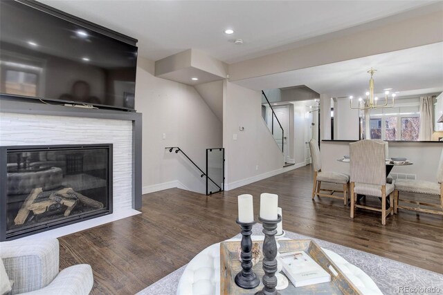 living room featuring dark hardwood / wood-style floors and an inviting chandelier