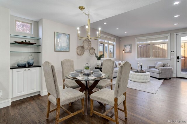 dining area with dark hardwood / wood-style flooring and a chandelier