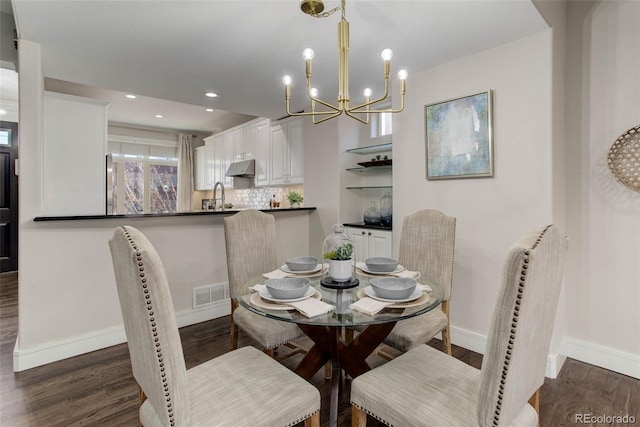 dining space featuring a chandelier, sink, and dark wood-type flooring