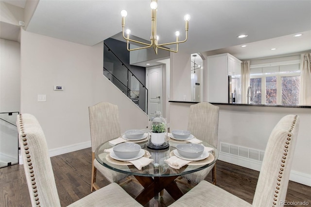 dining area featuring sink, dark wood-type flooring, and a notable chandelier