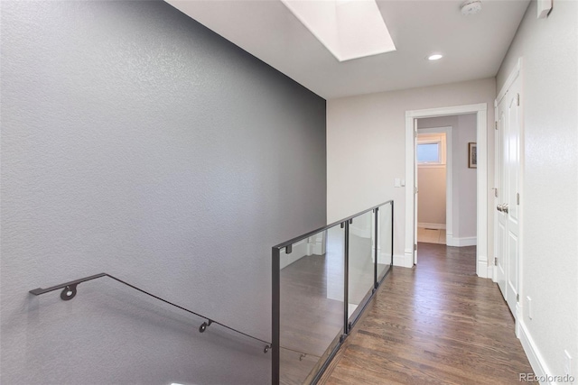 hallway with a skylight and dark hardwood / wood-style flooring