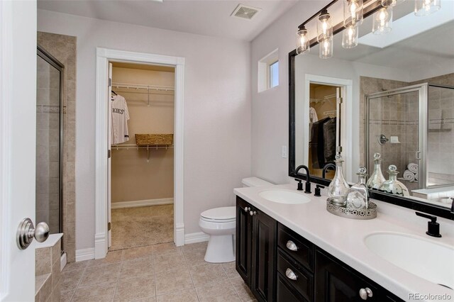 bathroom featuring tile patterned flooring, vanity, an enclosed shower, and toilet