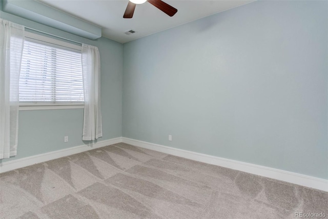 empty room featuring light colored carpet and ceiling fan