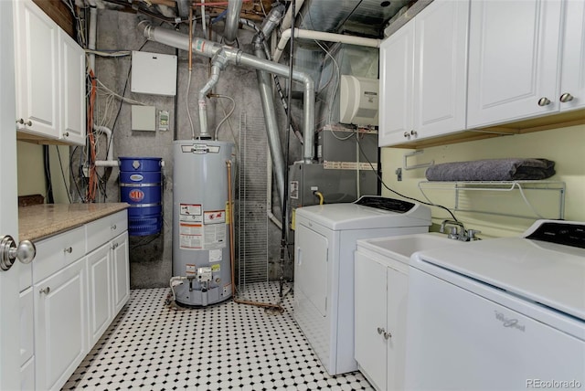 laundry room with water heater, cabinets, and independent washer and dryer