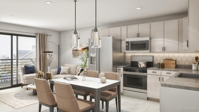 kitchen featuring decorative light fixtures, backsplash, stainless steel appliances, light hardwood / wood-style floors, and white cabinets