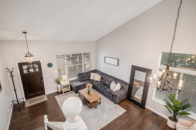 11681 Night Heron Dr, Parker, CO 80134 - living room with vaulted ceiling, a chandelier, dark wood-style flooring, and baseboards