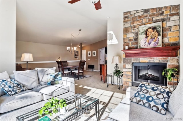 carpeted living room featuring ceiling fan with notable chandelier, a fireplace, and vaulted ceiling