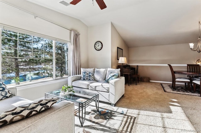 carpeted living room featuring vaulted ceiling and ceiling fan with notable chandelier