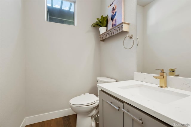 bathroom featuring vanity, hardwood / wood-style floors, and toilet