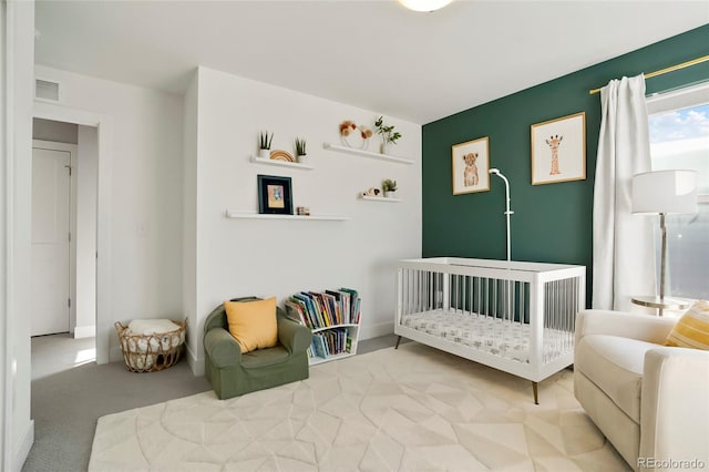 bedroom with a crib and carpet flooring