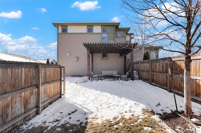 snow covered back of property featuring an outdoor hangout area and a pergola