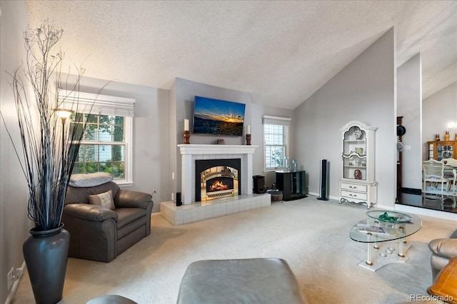 living room featuring carpet, a tiled fireplace, vaulted ceiling, and a textured ceiling