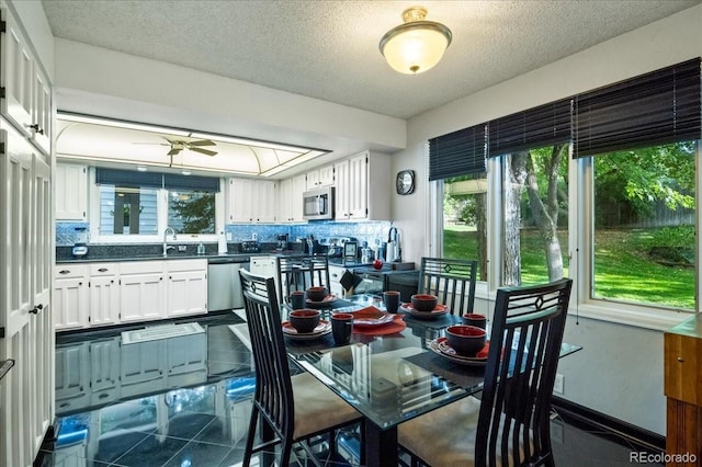 dining room featuring ceiling fan, sink, and a textured ceiling